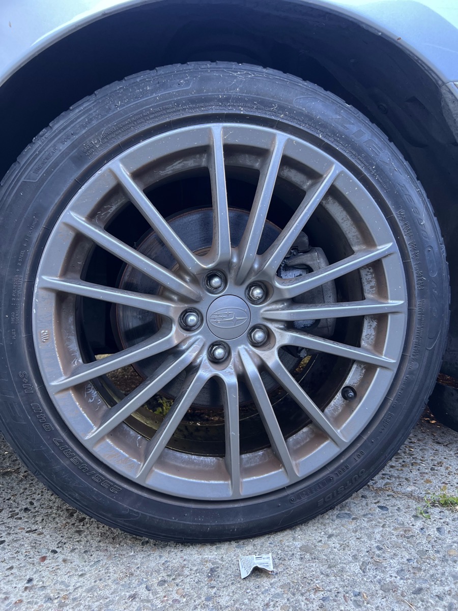 Subaru WRX wheel caked in brake dust before detailing